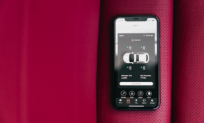 Smartphone displaying car control app on red seat — Foto por Erik Mclean na Unsplash
