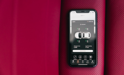 Smartphone displaying car control app on red seat — Foto por Erik Mclean na Unsplash