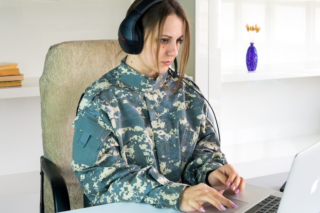 a woman wearing headphones sitting in front of a laptop computer — Foto por Bermix Studio na Unsplash